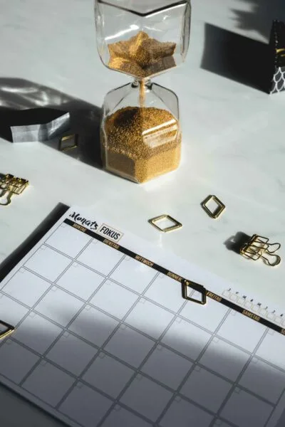 An hourglass with sand flowing from the top to the bottom, symbolizing the passage of time.